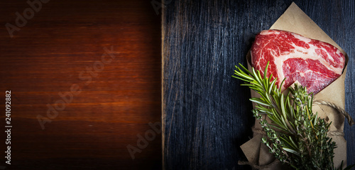 fresh rib-eye steak with rosemary, ready for frying.