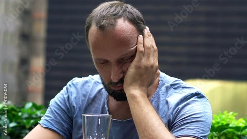 Drunk man drinking beer sitting in bar in the city