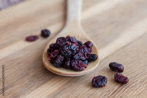 candied fruit (dried cranberry) on wooden spoon isolated