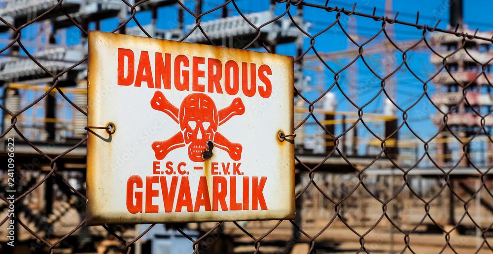 Danger Sign on a fence in English and Afrikaans language Danger Sign on a fence in English and Afrikaans language
