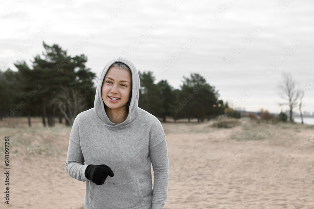 People, active lifestyle, vitality, sports and determinatio concept. Picture of beautiful slim young female athlete wearing black gloves and hoodie spending weekend outdoors, having walk or run People, active lifestyle, vitality, sports and determinatio concept. Picture of beautiful slim young female athlete wearing black gloves and hoodie spending weekend outdoors, having walk or run