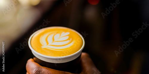 African Coffee Barista holding a take away cup