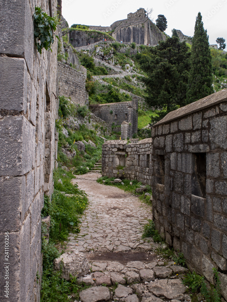 Old path leading through ancient walls of stone 