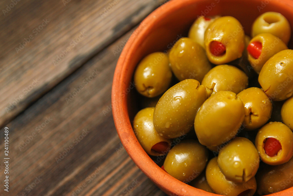 Olives filled with paprika in a retro style ceramic bowl on a old wooden table Olives filled with paprika in a retro style ceramic bowl on a old wooden table
