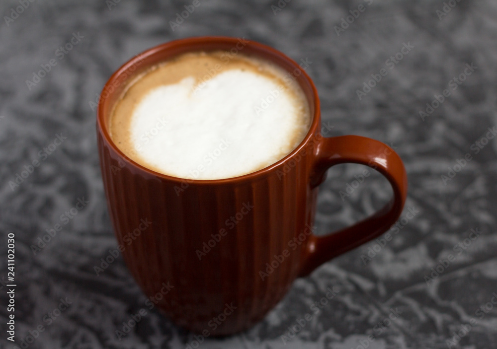 hot cappuccino coffee in a brown mug on a gray background hot cappuccino coffee in a brown mug on a gray background
