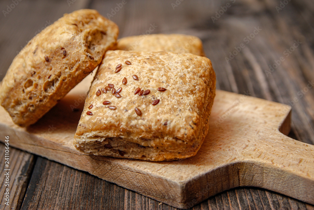 Healthy homemade pastry with integral flour and seeds on kitchen cutting board. Wooden table and rustic vintage background. Healthy homemade pastry with integral flour and seeds on kitchen cutting board. Wooden table and rustic vintage background.