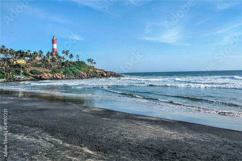 A beach in Kerala (India) with a lighthouse and clear blue sky