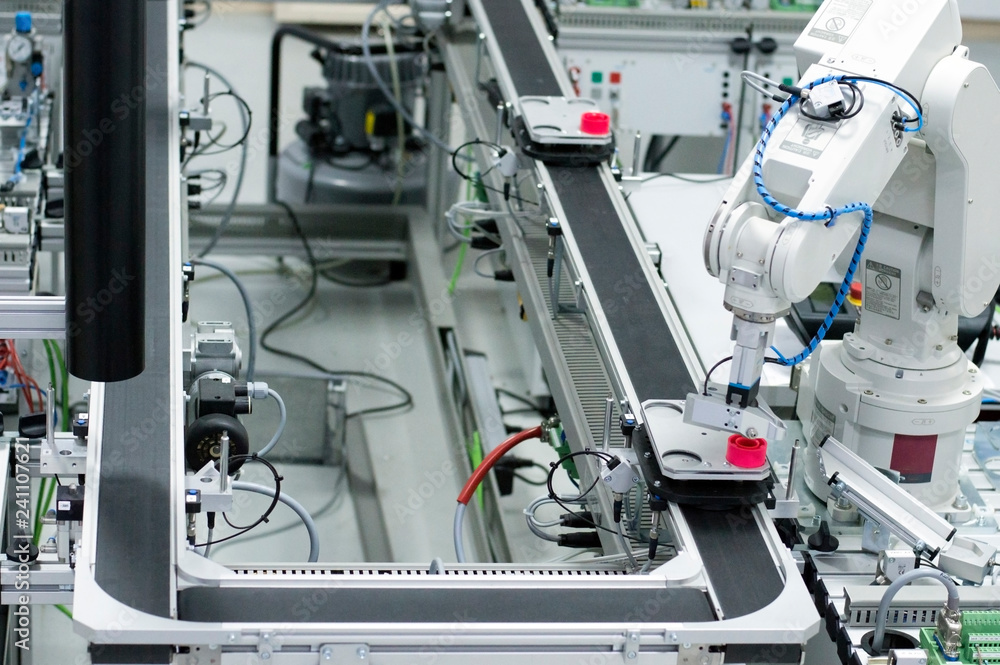 Gripper picks up the product from automated car which is on the manufacturing line in a smart factory. Industry 4.0 concept; artificial intelligence in manufacturing. Gripper picks up the product from automated car which is on the manufacturing line in a smart factory. Industry 4.0 concept; artificial intelligence in manufacturing.