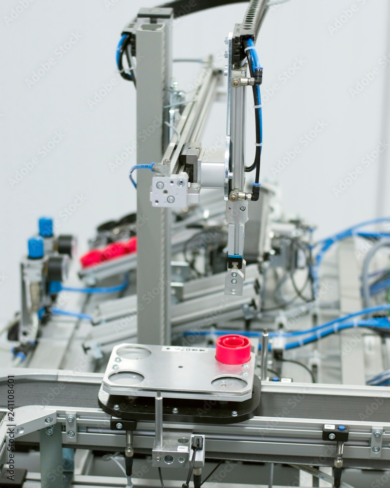 Gripper picks up the product from automated car which is on the manufacturing line in a smart factory. Industry 4.0 concept; artificial intelligence in manufacturing.