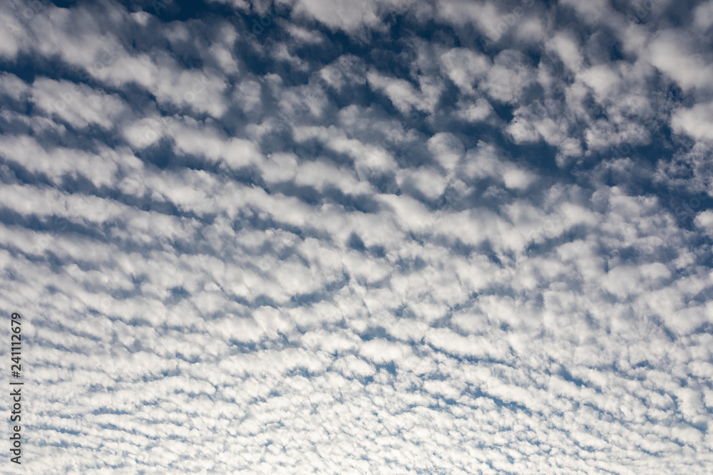 Cirrocumulus clouds against blue sky background pattern
