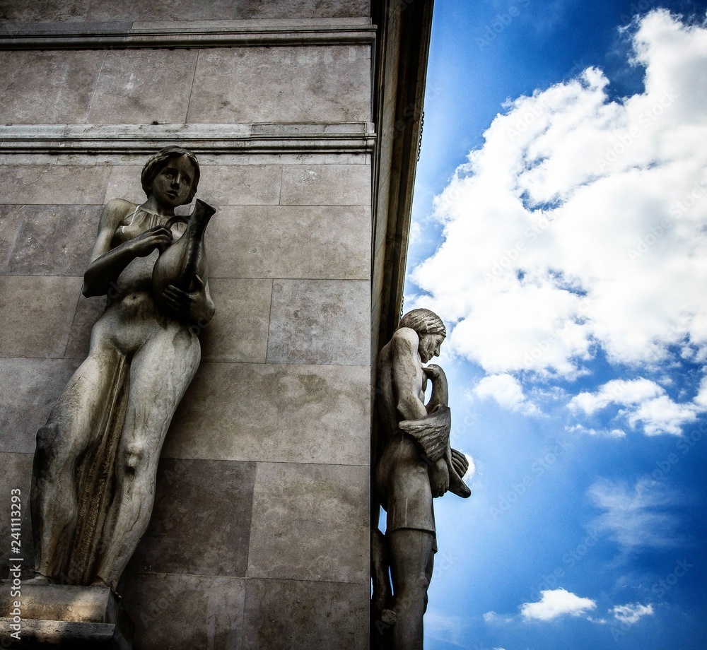 Naklejka premium 2 statues attached to the frontage of a house in budapest