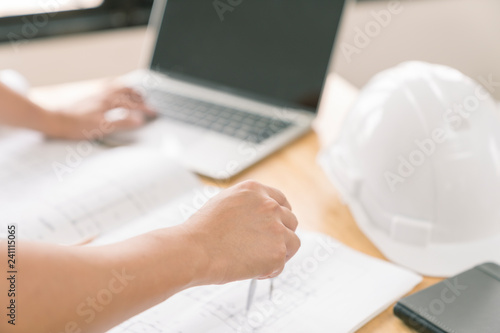 architect or civil engineer during drawing home or building in office on working table with office stationary , laptop ,color pallette sampling.