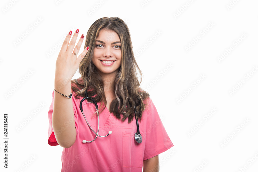 Portrait of beautiful young doctor wearing scrubs showing number four Portrait of beautiful young doctor wearing scrubs showing number four