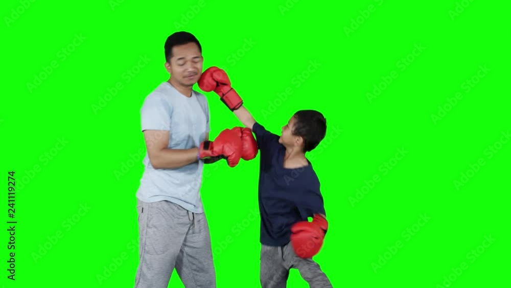 Young man teaching his son boxing exercise in the studio. Shot in 4k resolution with green screen background Young man teaching his son boxing exercise in the studio. Shot in 4k resolution with green screen background