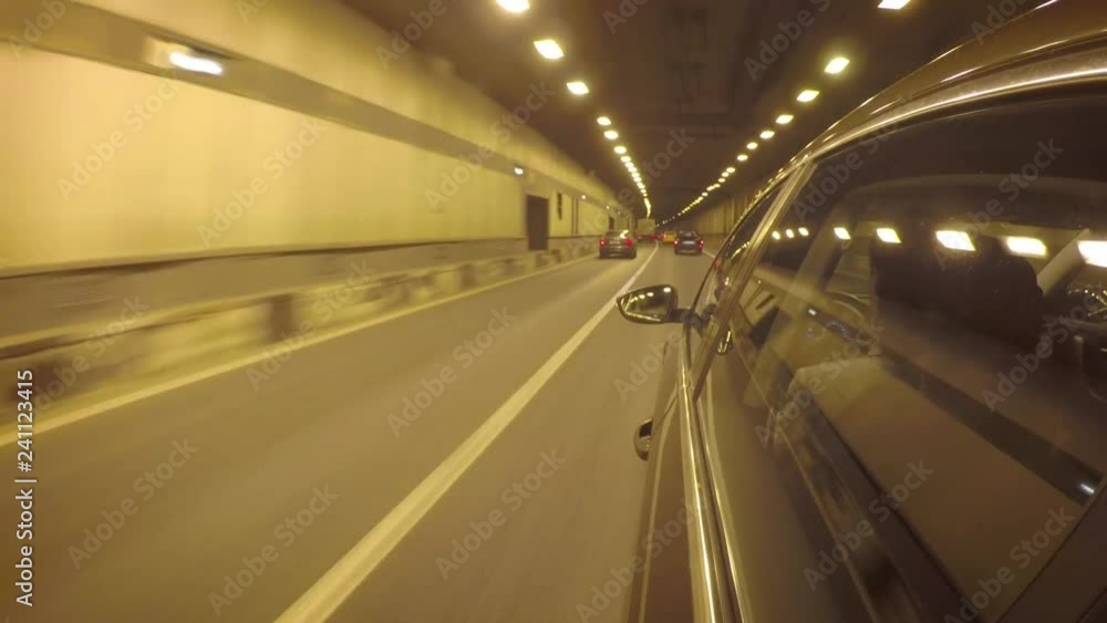 The car goes through the tunnel in heavy traffic. Side view from the car body The car goes through the tunnel in heavy traffic. Side view from the car body