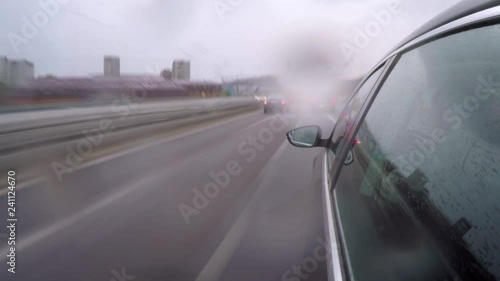 Timelapse of the car on the city highway in rush hour along in the rain. Side view from the car body