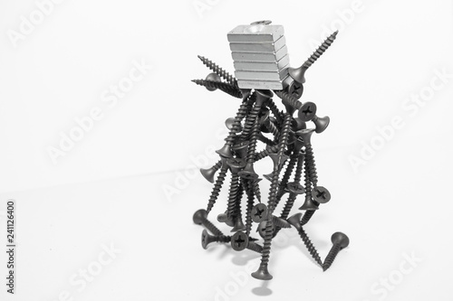 Abstract figurine of black self-tapping screws hanging on the magnet
