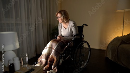 Mature granny looking at window waiting for children, patient of nursing home