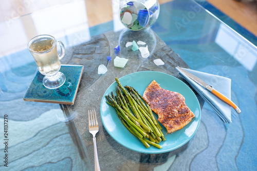 Keto lunch or dinner meal with seasoned cooked salmon, asparagus stalks and a carb-free drink