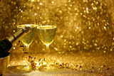 Kieliszki i butelka z szampanem na złotym, błyszczącym tle.