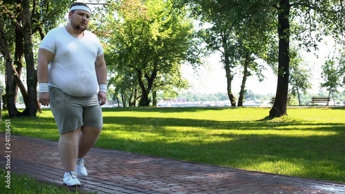 Man walking slowly, exhausted after running, cardio training for weight loss photo