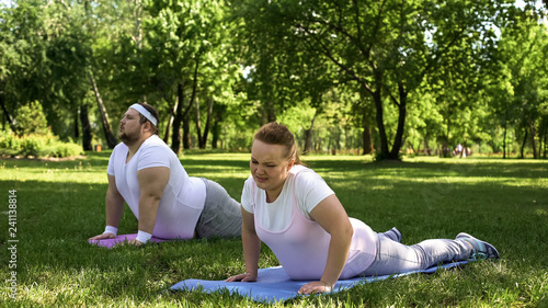 Foto Tired but strong-willed fat people force themselves to do fat-burning routine