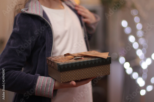 Children's hands hold gift box