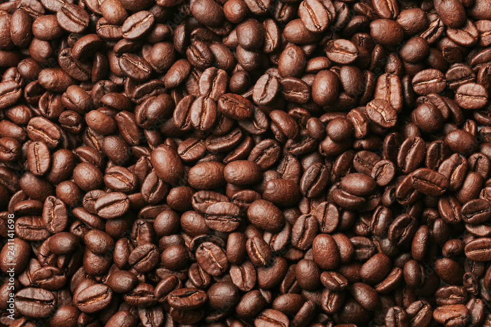 Dark brown roasted coffee seeds artistic pattern background. Dark brown roasted coffee seeds artistic pattern background.