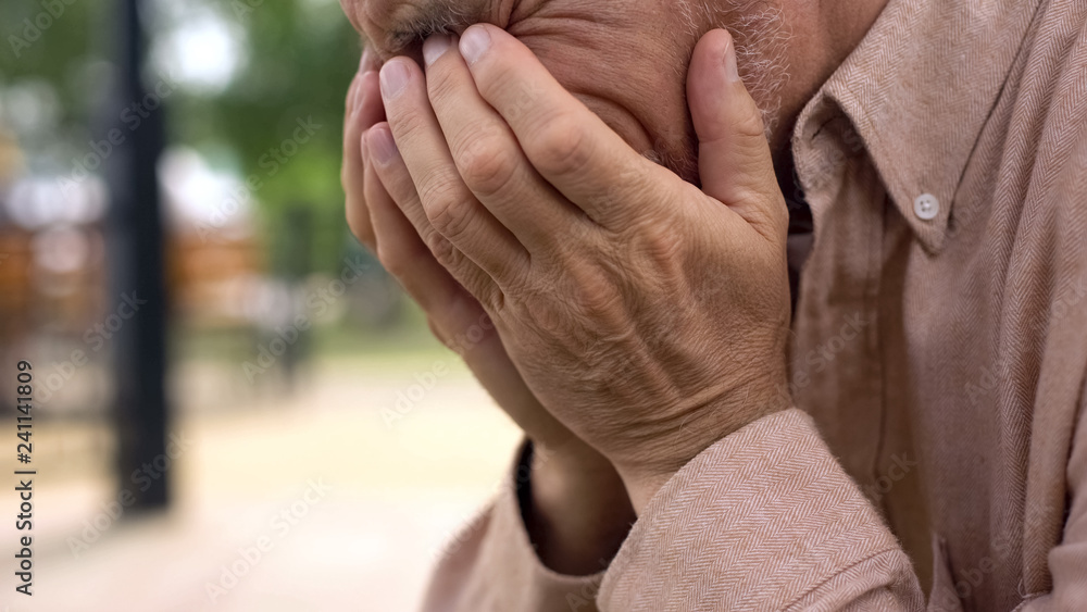 Aged retired man crying close-up, covering face with hands in despair, sorrow Aged retired man crying close-up, covering face with hands in despair, sorrow