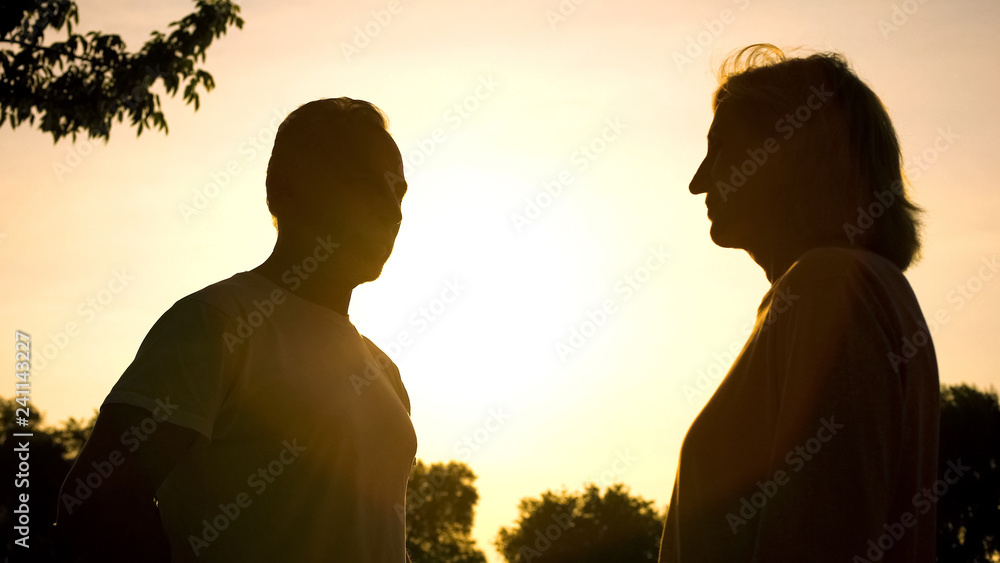 Silhouette of old man hiding flowers for woman, romantic date, attention, care