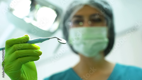 Female stomatologist preparing to exam patient teeth  treatment of toothache