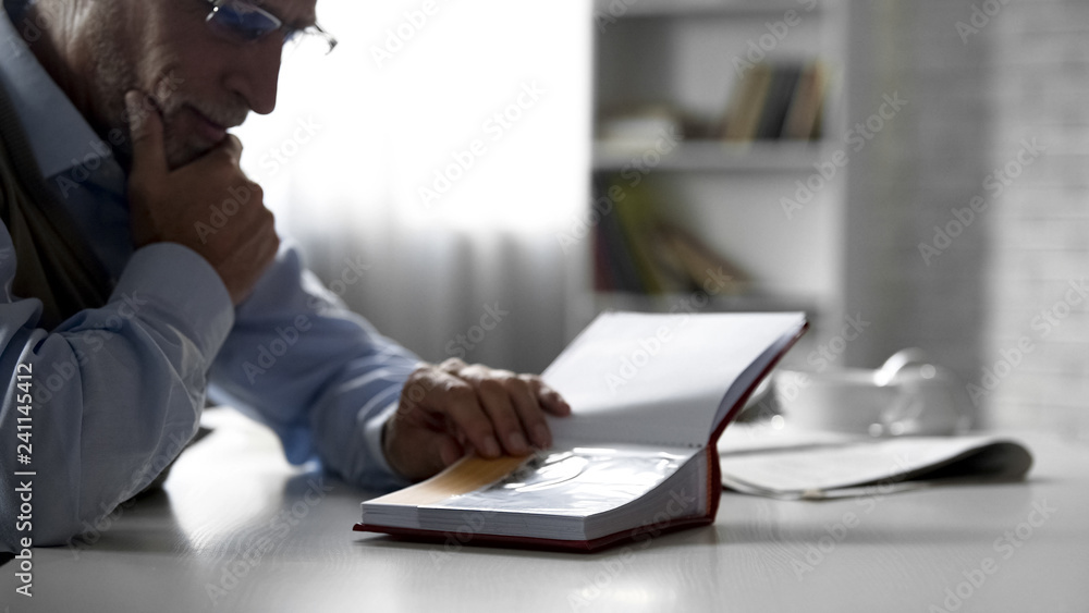 © motortion - Elderly male looking at photos in album at kitchen table, pleasant memories © motortion - Elderly male looking at photos in album at kitchen table, pleasant memories