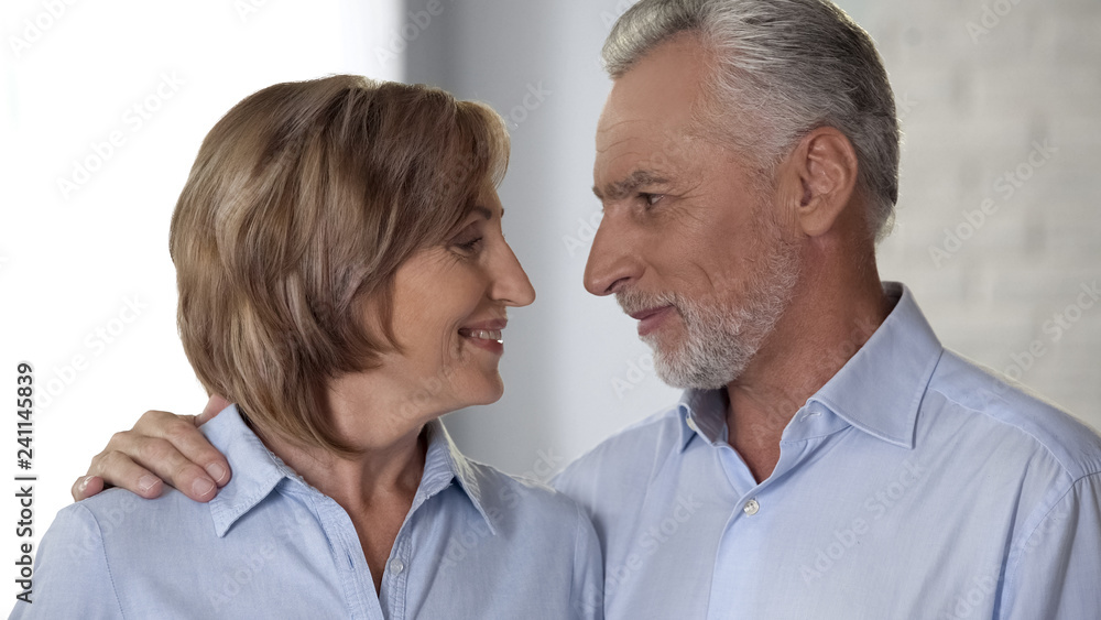 Joyful retiree man and lady looking at each other and smiling, harmony and love Joyful retiree man and lady looking at each other and smiling, harmony and love