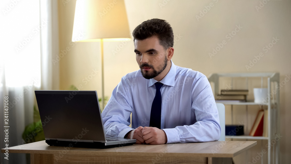 Young male freelancer having job interview on laptop at home, unemployment Young male freelancer having job interview on laptop at home, unemployment