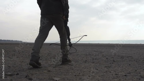 Walking Dangerous zombie monster with heavy Cross bow in Wasteland. Horror Character concept, Armed and grasepainted entity photo