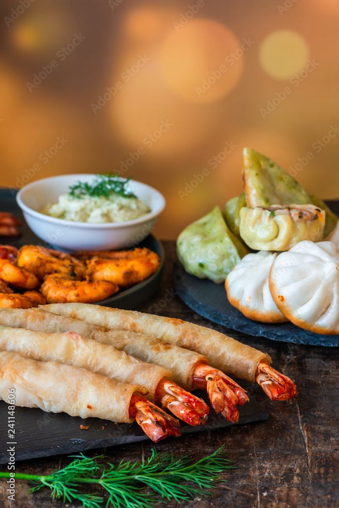 Giant king prawns and selection of mini Chinese dumplings with yogurt dipping sauces. Party food idea. Giant king prawns and selection of mini Chinese dumplings with yogurt dipping sauces. Party food idea.