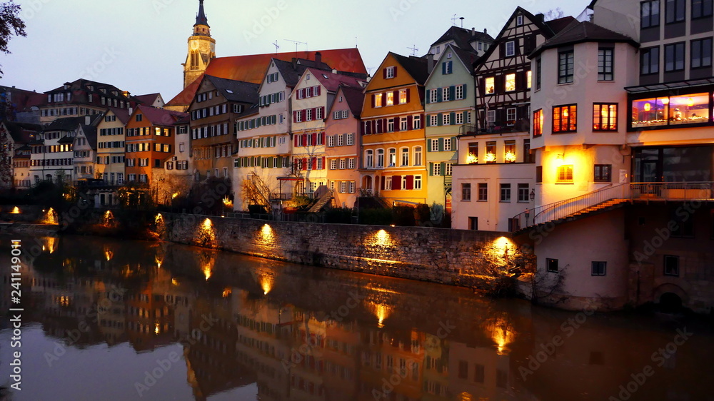 Häuser entlang des Neckars in Tübingen spiegeln sich im Abendlicht im Wasser