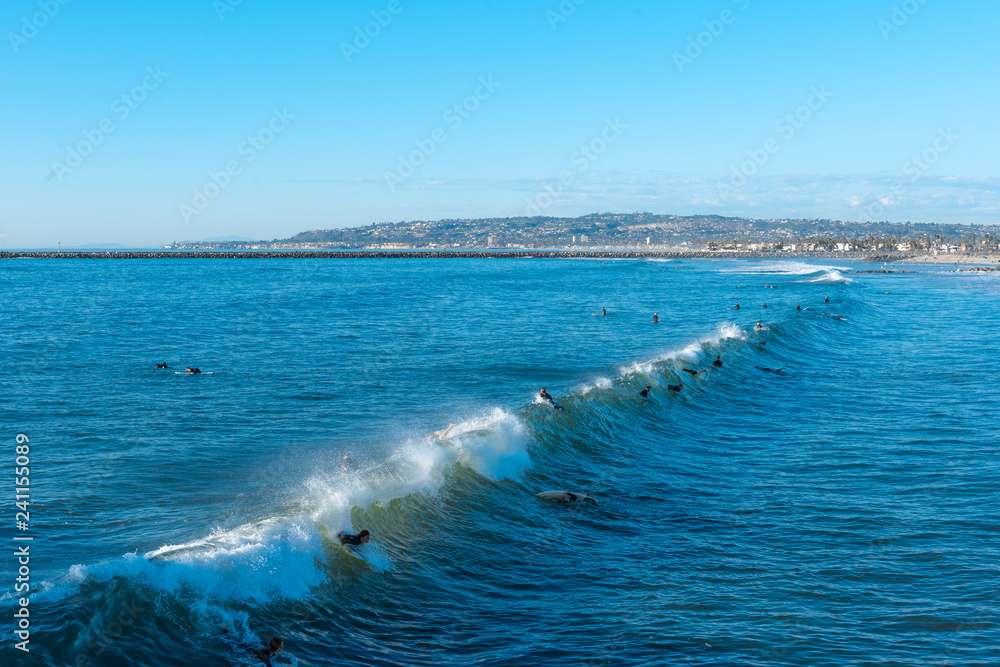 People surfing in the sea with clear blue sky