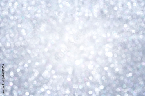 High resolution silver colored blurred bokeh background. Abstract full frame shiny glitter background for Christmas, New Year, holiday season and celebration. Vignetting and brighter in the middle.