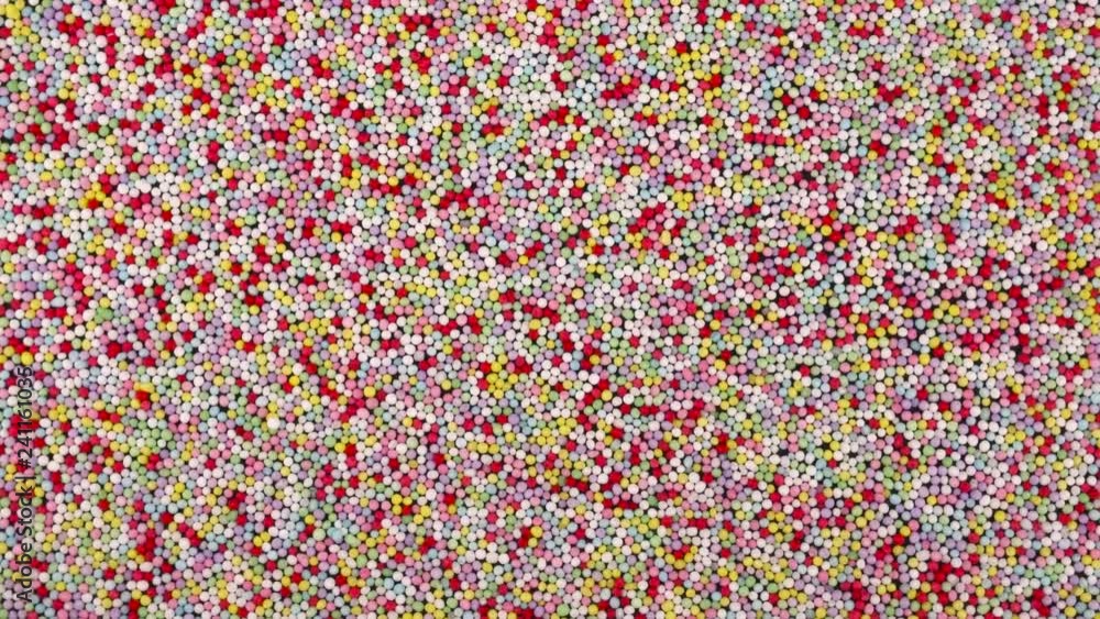 Top view from above of small colorful sprinkles sugar candies rotating. Background. Top view from above of small colorful sprinkles sugar candies rotating. Background.