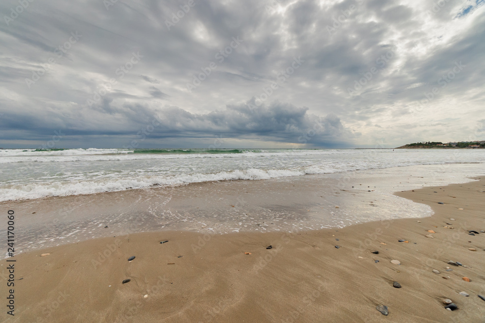 View of the sea from the beach under a stormy sky