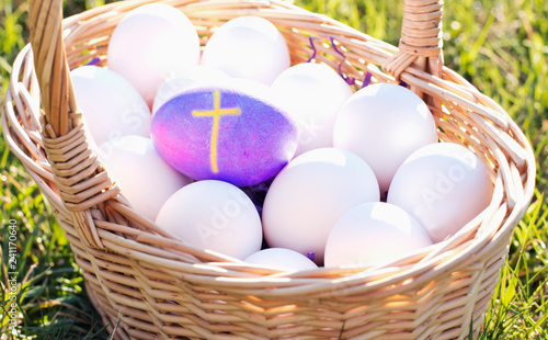 Purple Egg with Cross among basket of White Eggs
