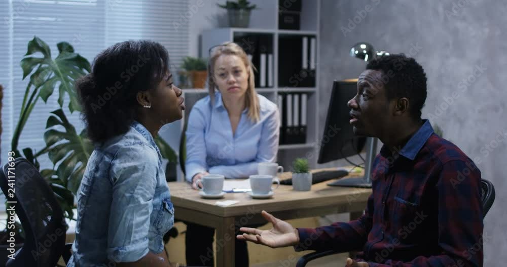 Medium long shot of psychologist intervening into an argument of a couple Medium long shot of psychologist intervening into an argument of a couple