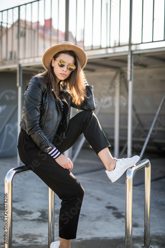 Portrait of young beauty woman in fanky hat and sunglasses in skatepark outdoors photo