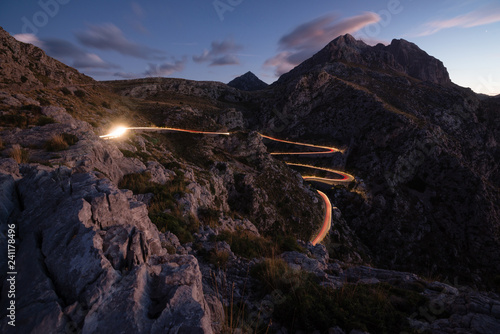 Sa Calobra road lit by the light of car at dusk, Mallorca island, Spain photo