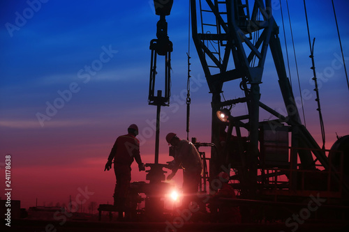 Oil workers work in the evening at the oil field