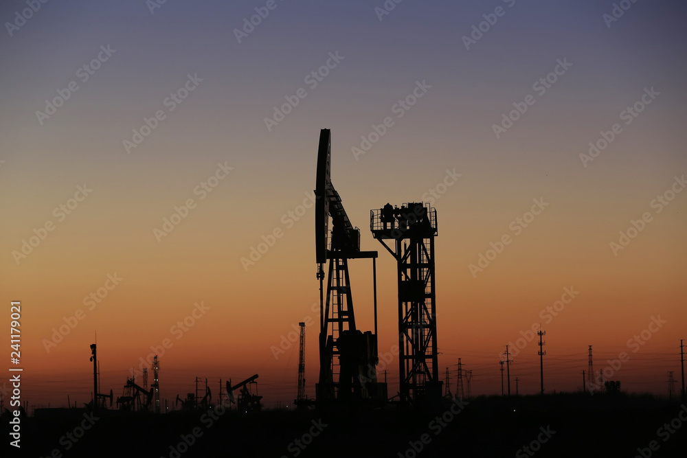 The pumping unit is at work in the evening of the oilfield The pumping unit is at work in the evening of the oilfield
