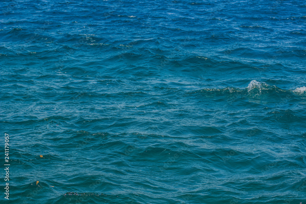 Fototapeta premium vivid blue sea water surface with waves background wallpaper scenic view