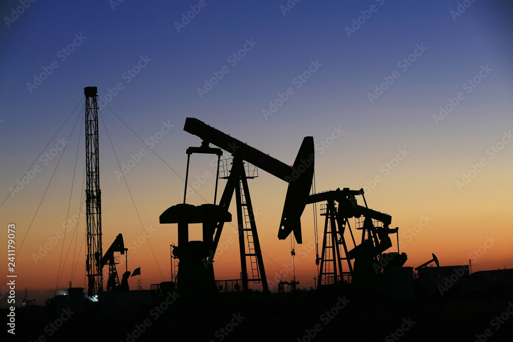 The pumping unit is at work in the evening of the oilfield The pumping unit is at work in the evening of the oilfield