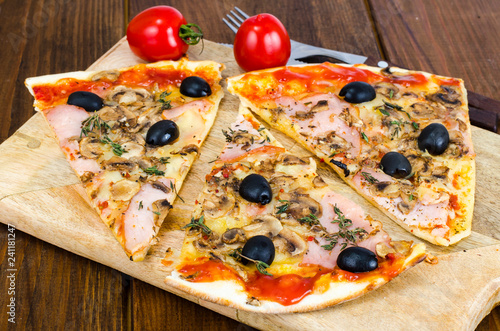 Sliced pizza with mozzarella cheese, ham, mushrooms, olives